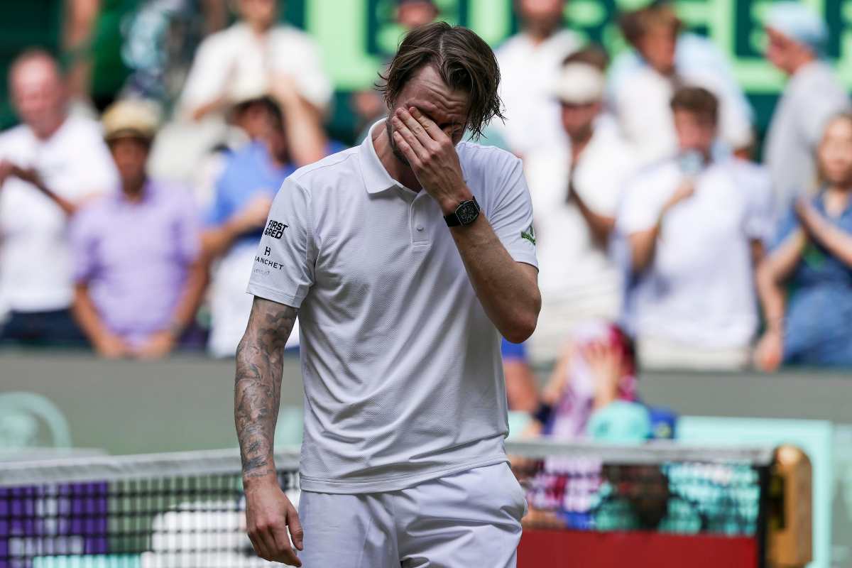 Bublik, vestito di bianco, si porta la mano sinistra al volto