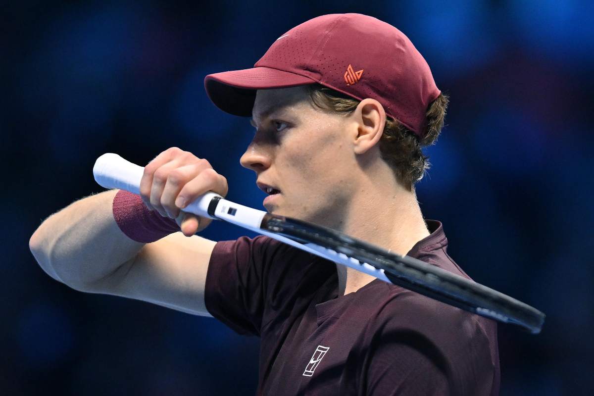 Jannik sinner, immortalato di profilo, si asciuga il sudore mentre imbraccia la racchetta